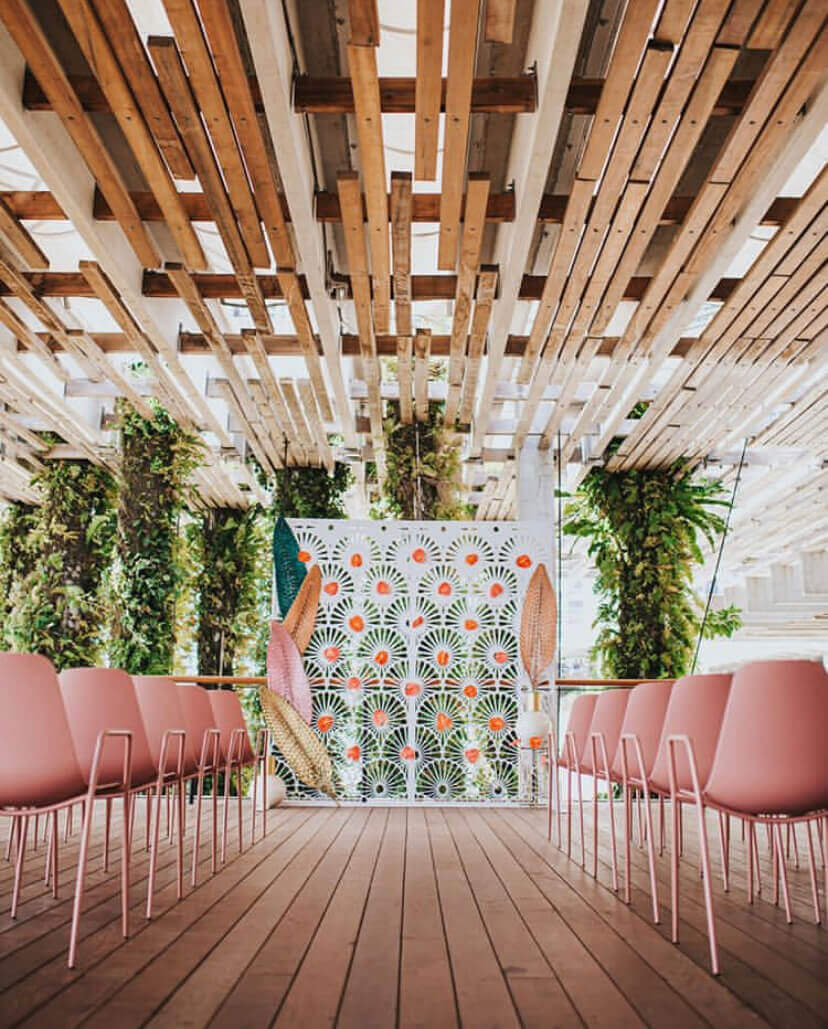 Pink wedding ceremony chairs in tropical theme